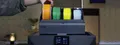Close context image of the QIDI Box mounted on a Plus5, with a user loading colored filament spools.