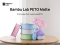 Official Bambu Lab PETG Matte promotional context image, 1920 x 1440: filament spools and printed decor including a violet mushroom lampshade. Includes manufacturer branding and promotional text; not exclusively the Violet variant.