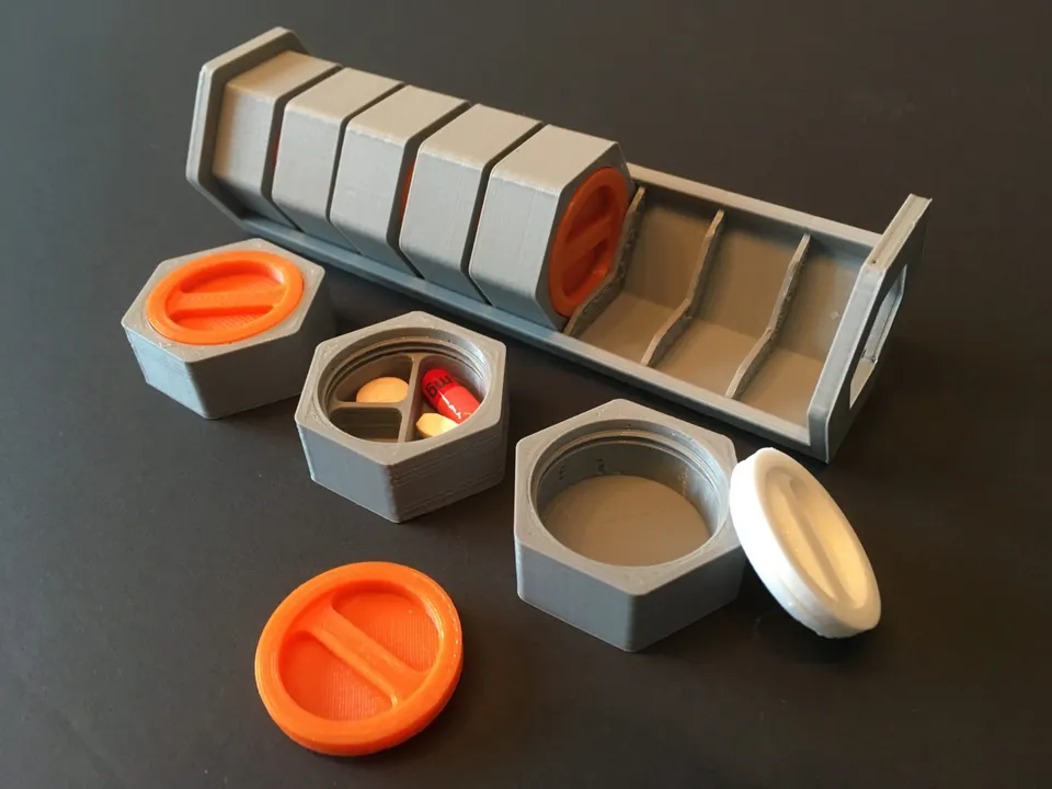 Modulární 3D tištěná cestovní krabička na léky s oddělenými šestihrannými přihrádkami a šroubovacími víčky.