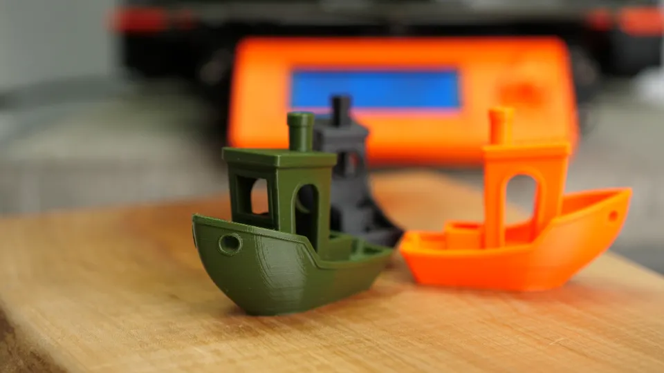 Tři 3D tištěné modely lodiček z různých filamentů jako ukázka porovnání materiálů PLA, PETG a ASA.