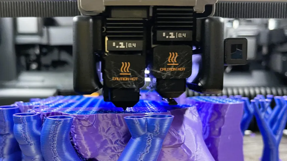 Dvoutrysková tiskárna Bambu Lab H2D tiskne složitý model s podpěrami.