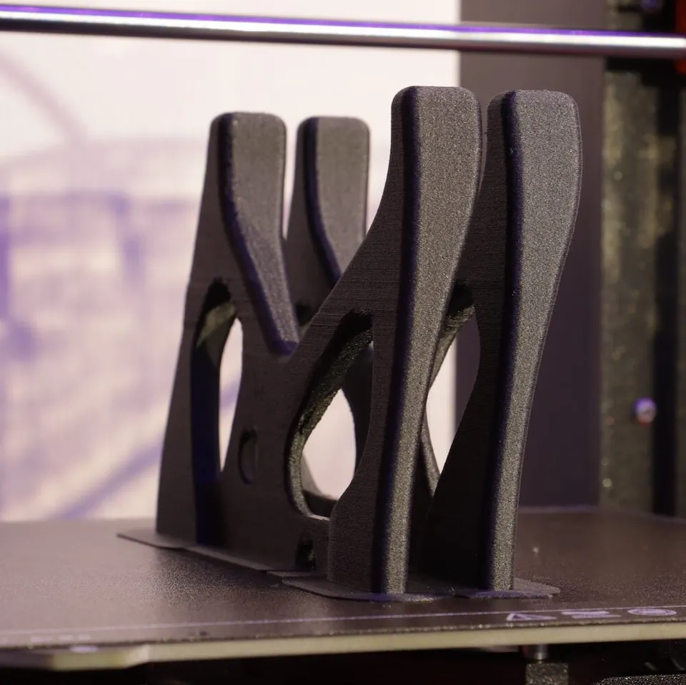 Detail 3D tištěného technického dílu z nylonového filamentu PA12-CF s viditelnými vrstvami a povrchem po tisku.