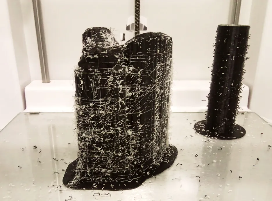 Purge tower a ooze shield jako zbytky materiálu vzniklé při vícebarevném 3D tisku.